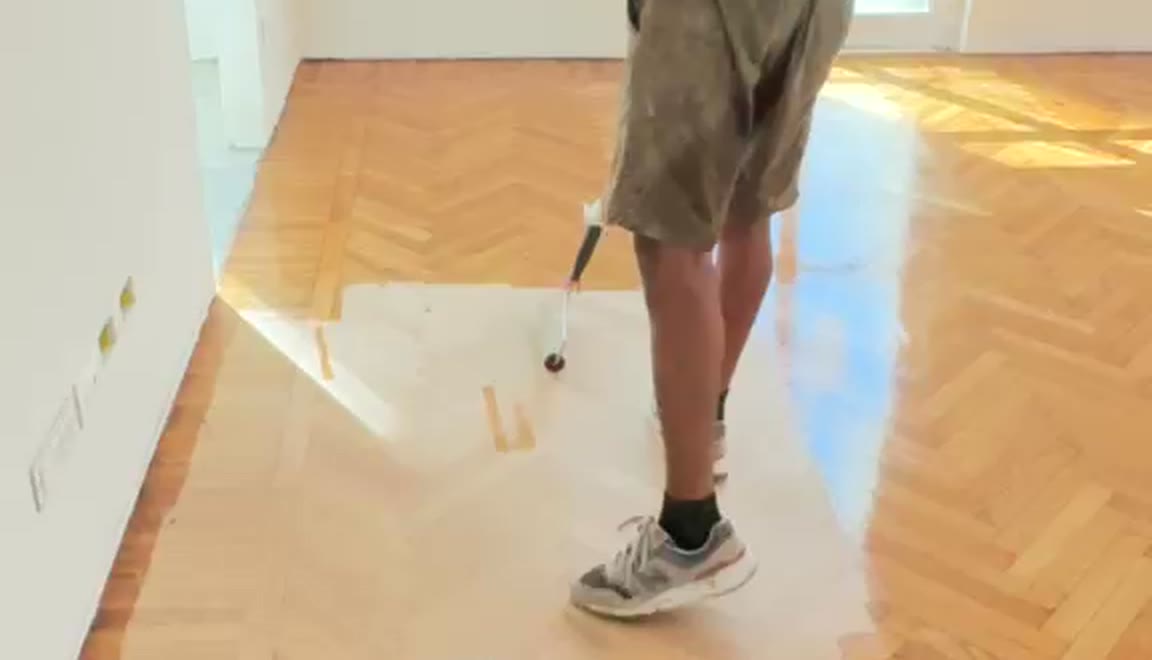 Stesura della finitura su un parquet appena levigato: il legno torna lucido