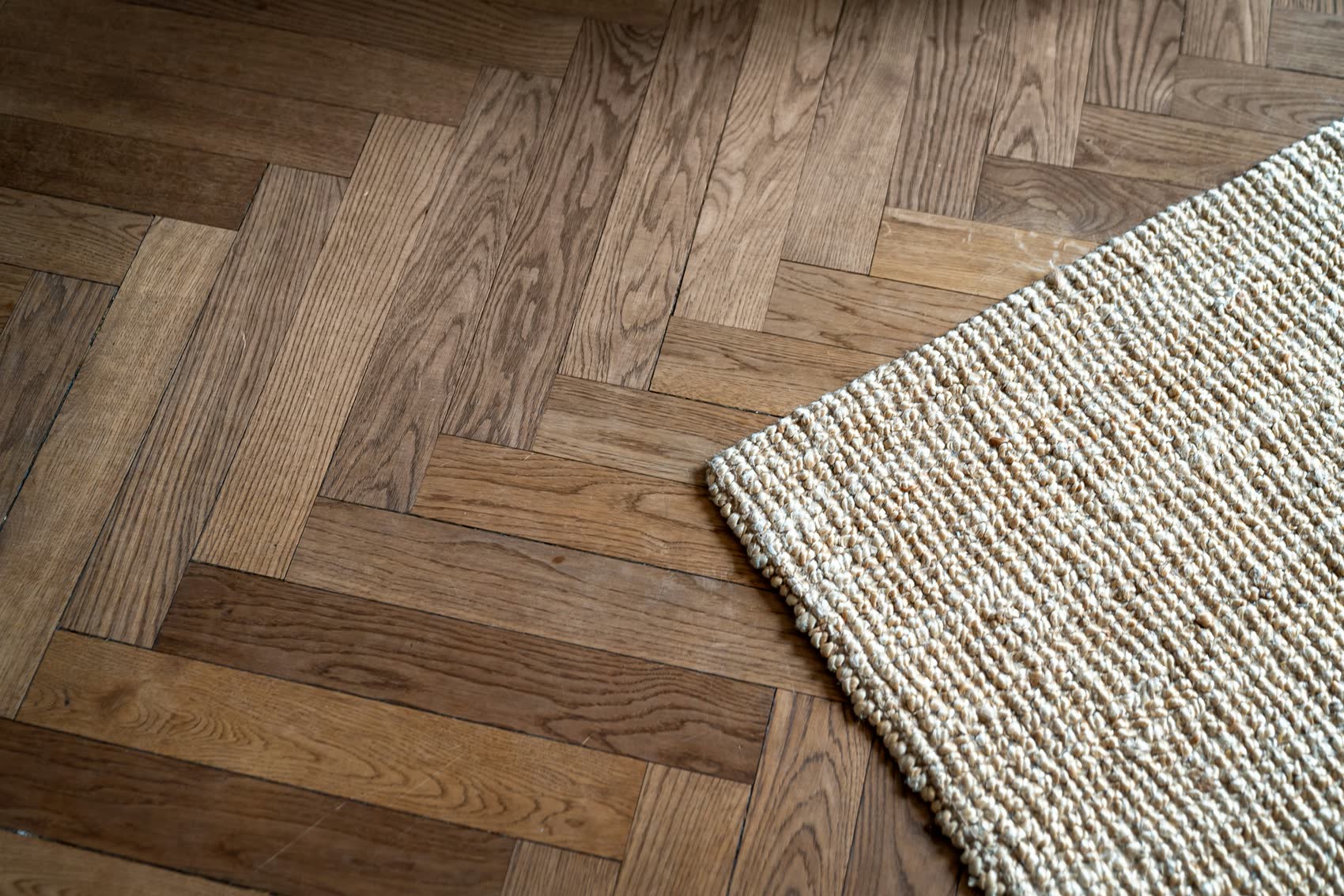 Parquet a spina in rovere con tappeto, in un interno di pregio