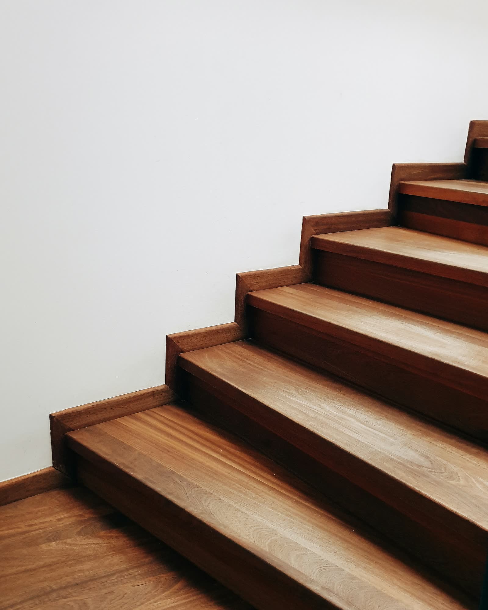 Gradini di una scala interna rivestiti in legno, in continuità con il pavimento